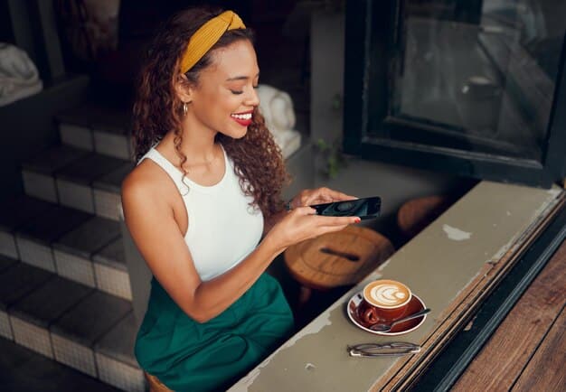 A customer scanning a QR code at a coffee shop using their smartphone to redeem loyalty points from a mobile loyalty program. The barista is smiling, and the environment is bright and welcoming.