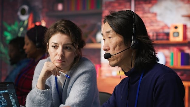 Two customer service agents are engaging in a role-playing scenario, one acting as the customer with a concerned expression, while the other listens attentively and takes notes. The setting is a brightly lit workspace with team members working at computers in the background.