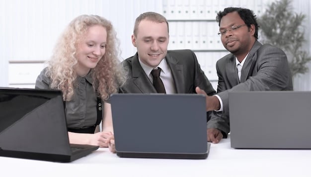 A group of employees participating in a business continuity training session, using laptops and discussing emergency response protocols. The image illustrates the importance of employee training and preparedness in a BCP.
